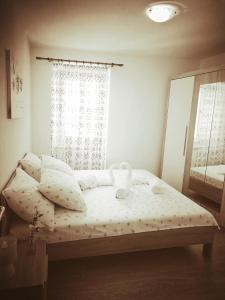 a small bedroom with a bed with a window at Apartment Michael in Krk