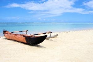 a boat sitting on a sandy beach near the ocean at Hotel le Lagon in Foulpointe
