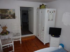 1 dormitorio con armario blanco y TV en KOWALÓWKA, en Mirsk