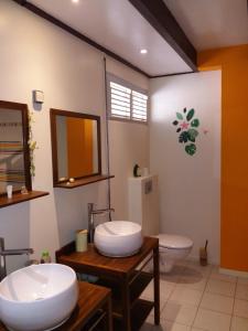 een badkamer met 2 wastafels en een toilet bij Chambre d'hôte La Villa Gialla in Schœlcher
