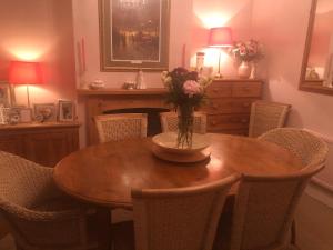 - une table à manger avec un vase de fleurs dans l'établissement Victorian Cottage, à Deal