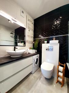 a bathroom with a sink and a washing machine at "Golden Sand & Sea" - Nowoczesny apartament w Kołobrzegu 47m2 in Kołobrzeg