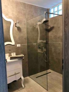 La salle de bains est pourvue d'une douche avec une porte en verre. dans l'établissement Apartment Luxury, à Râmnicu Vâlcea