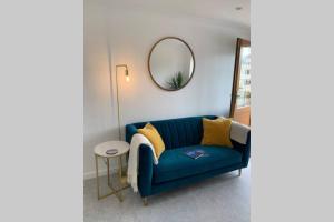 a blue couch in a room with a mirror at Rose Mews Central Broadstairs in Kent