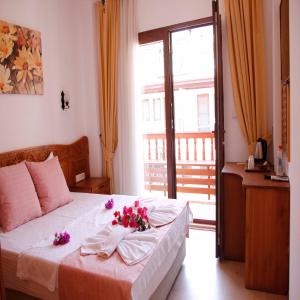 a bedroom with a bed with flowers on it at Limon Otel in Akyaka
