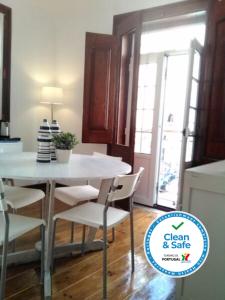 a kitchen with a white table and chairs in a room at Inglesinhos 1 in Lisbon