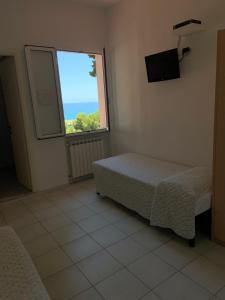 a bedroom with a bed and a window at Baia dei Gabbiani in San Lorenzo al Mare