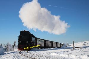 a train is traveling down the tracks in the snow at Ferienwohnung Both in Wernigerode