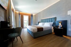 a bedroom with a bed and a chair in it at Hotel Bell'arrivo by Dori in Peschiera del Garda