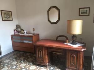 um quarto com uma mesa com um candeeiro e uma cómoda em Via ROMA em Montevarchi