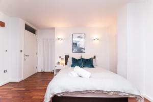 ニューカッスル・アポン・タインにあるNewcastle Penthouse - Sleeps 8 - City Centre - Free Parking - City Viewsの白いベッドルーム(青い枕の大型ベッド付)
