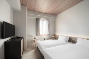 Llit o llits en una habitació de Nest Hotel Hiroshima Ekimae