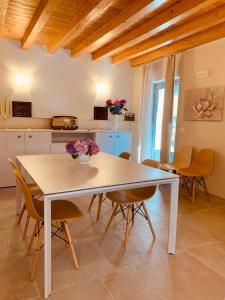 a dining room table with chairs and a kitchen at Cabanè Bed and Breakfast in Garlenda