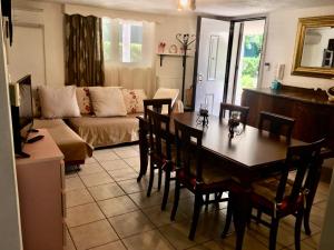 een woonkamer met een tafel en stoelen en een bank bij Apartment near airport and beach in Artemida