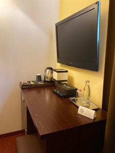 a hotel room with a desk with a flat screen tv at Hotel City Inn Hamburg-Mitte in Hamburg