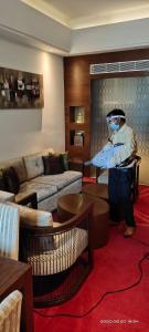 a person wearing a mask in a living room at The Landmark Towers in Kānpur