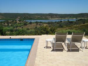 2 sillas y una mesa junto a la piscina en Casa da Paz, en Odeleite