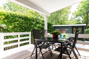a patio with a black table and chairs at Chalet aan de kust in Sint Maartensvlotbrug