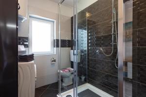 łazienka z przeszklonym prysznicem i toaletą w obiekcie APARTMANI KAROCA 3 w Puli +37 zdjęć