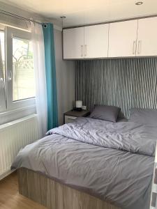a bedroom with a bed with white cabinets and a window at Domki nad morzem in Gdańsk
