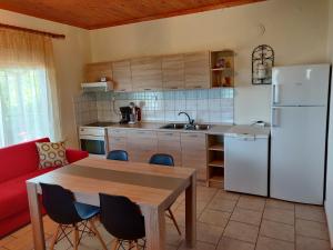 uma cozinha com uma mesa e um frigorífico branco em Seaview Home em Loutrá Elevtherón