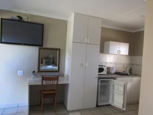 una cucina con bancone e una cucina con frigorifero di At Home BB a Estcourt Altre 15 foto
