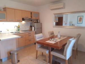 a small kitchen with a wooden table and chairs at Lovely apartment Branko Rabac with balcony and parking in Rabac