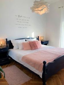 Schlafzimmer mit einem Bett mit rosa und weißen Kissen in der Unterkunft Apartment Agava Istria - family vacation rental with free parking, garden, WiFi in Ližnjan
