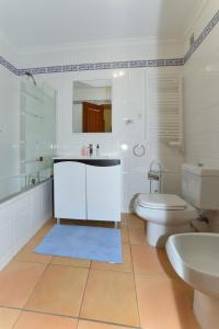 a white bathroom with a toilet and a sink at Spectacular Mar a Vista in Portimão