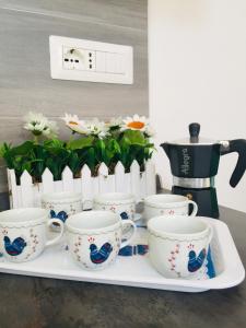 a tray with four coffee cups and a coffee pot at Il Quarzo A) B) in Càbras