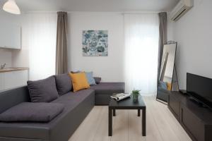 salon z szarą kanapą i stołem w obiekcie Apartments Antons 2 w Puli