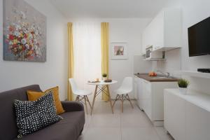 a living room with a couch and a kitchen at Apartments Antons 2 in Pula
