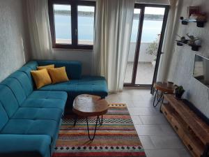 a living room with a blue couch and a table at Villa Nada in Rab