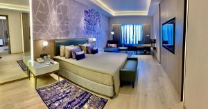 a bedroom with a large bed and a living room at Vivanta Vadodara in Vadodara