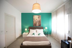1 dormitorio con cama y pared azul en B&B Brothers Suite Vomero en Nápoles