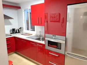una cocina roja con armarios rojos y fregadero en Casa Charo en Santa Cruz de la Palma