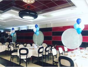 un comedor con mesas blancas y globos azules en Hotel Pami, en Cluj-Napoca