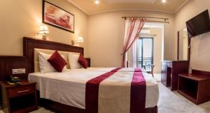 a bedroom with a large bed and a balcony at Hotel Villa Nisteri in Limenas
