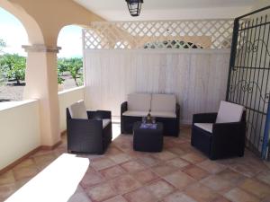 een patio met 2 stoelen en een tafel op een veranda bij Residenza Rosa Maria Country House in Orosei