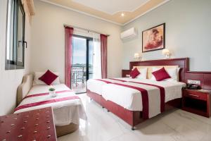 a hotel room with two beds and a balcony at Hotel Villa Nisteri in Limenas