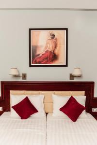 a bedroom with two beds with red and white pillows at Hotel Villa Nisteri in Limenas