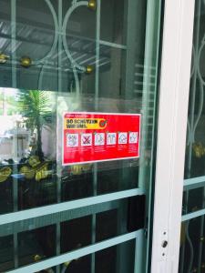 a red sign on a window of a building at thai-scout in Pran Buri