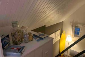 a room with a shelf with a jar and books at Petit loft SAINT-MALO intra-muros in Saint Malo