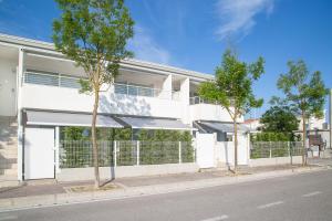 a white building with trees in front of it at MARINA PONENTE in Lido di Jesolo