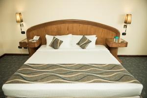 una camera da letto con un grande letto con due comodini di Cherry Maryski Hotel ad Alessandria d'Egitto