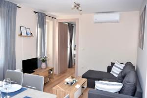 ein Wohnzimmer mit einem Sofa und einem Tisch in der Unterkunft New Fortress Corfu Apartment in Korfu-Stadt