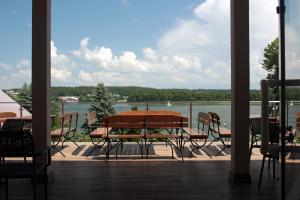 a patio with a table and chairs and a view of a lake at Hotel Huszcza in Mrągowo