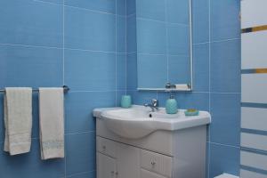 a blue bathroom with a sink and a mirror at Casa Olhos de Mar - 7 min pé Praia in Peniche +34 photos