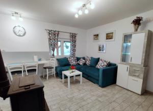 a living room with a blue couch and a table at Holiday Home Rojko in Štrigova