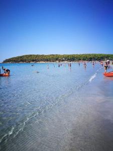 people on surfboards in the water at Affittacamere la Medusa in Porto Pino
